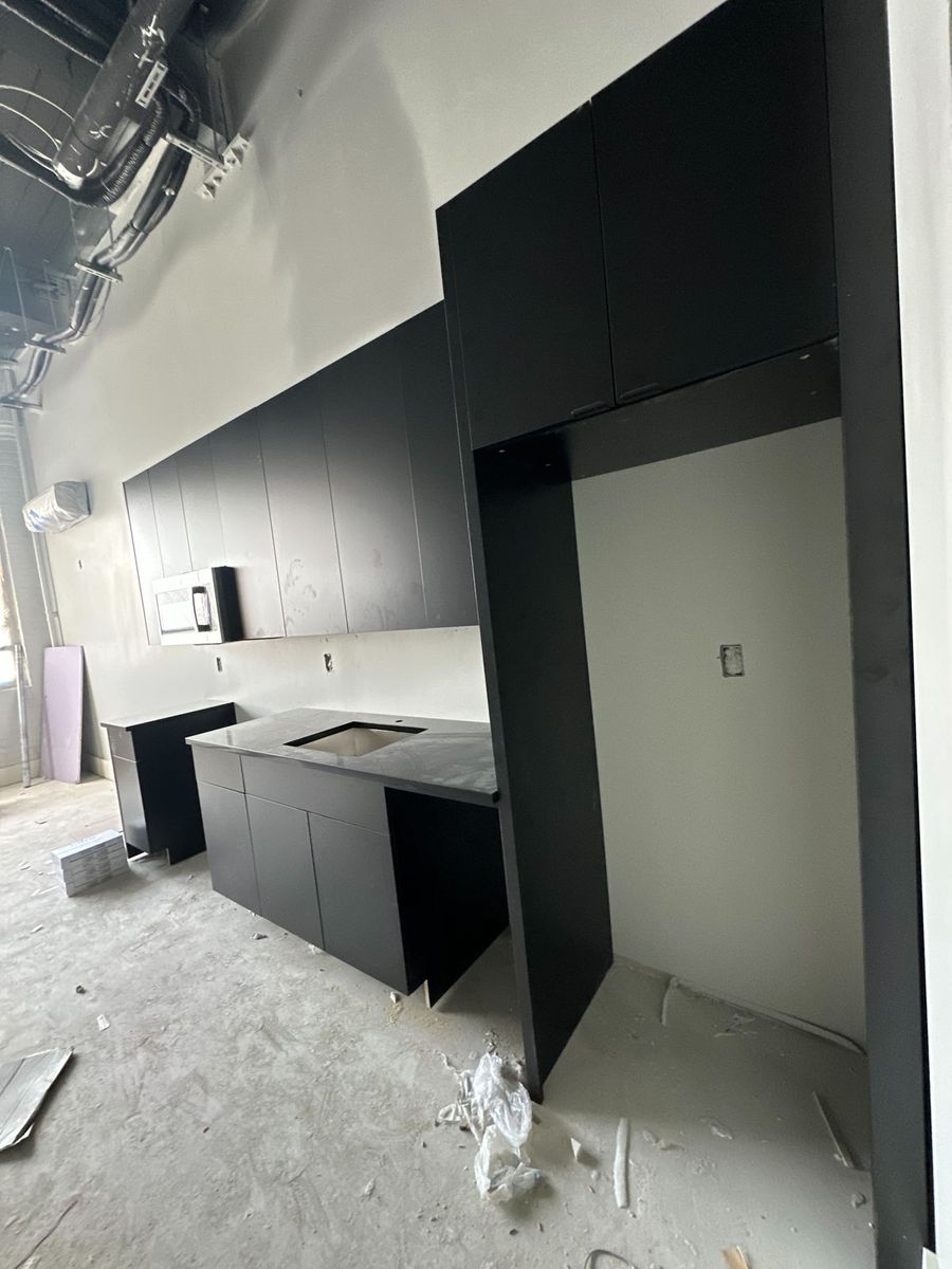 Long run of matte black multifamily kitchen cabinets under construction, Bristle & Main, Hartford CT