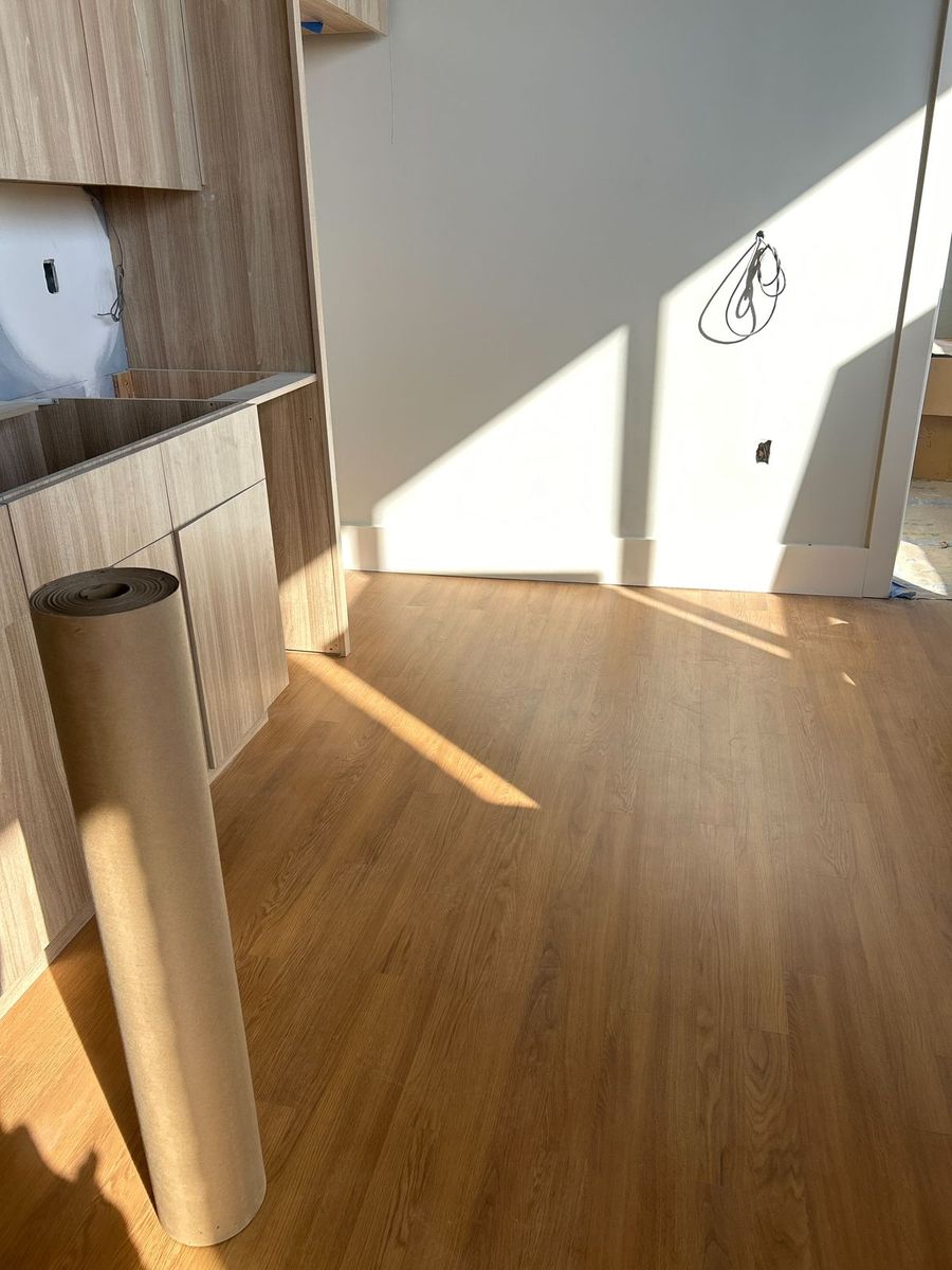Light wood-grain apartment kitchen cabinets being installed on a multifamily jobsite