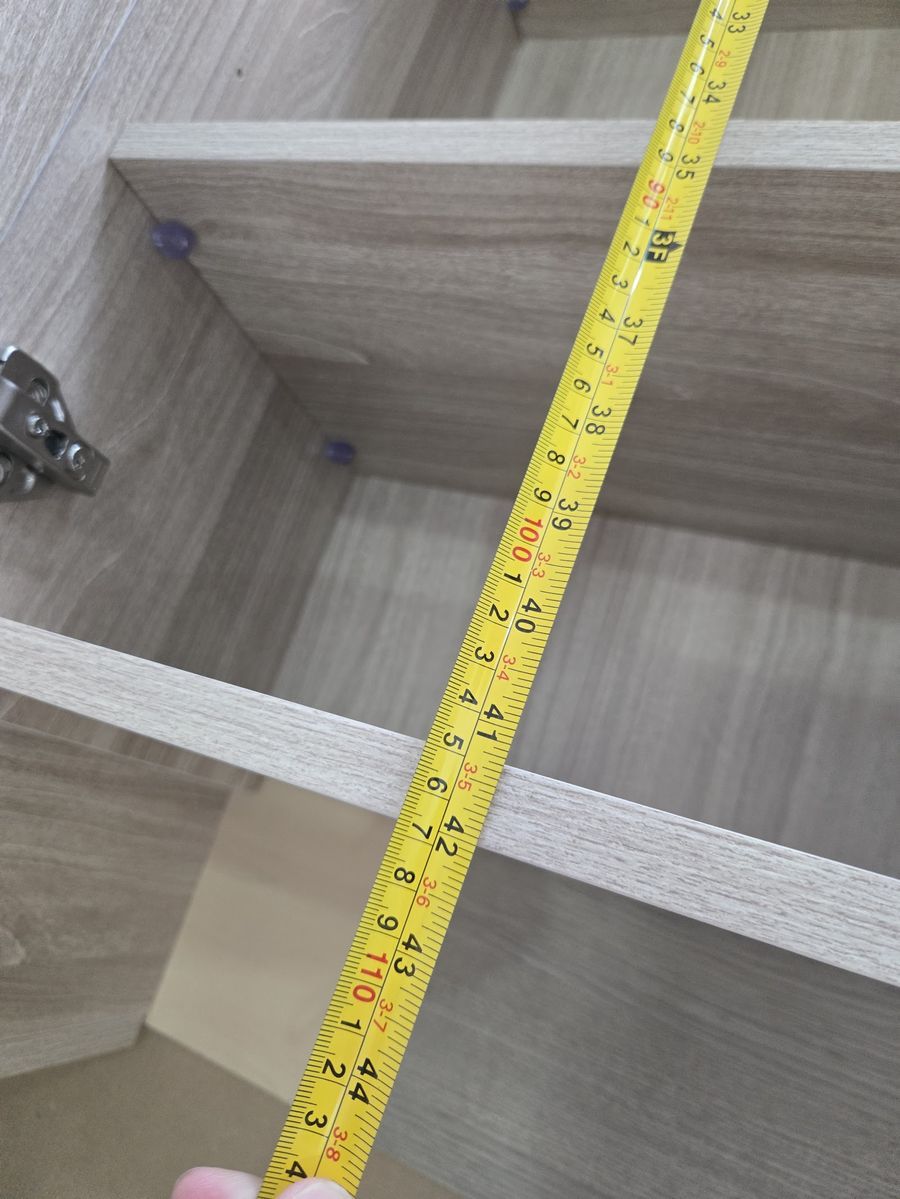 Tape measure checking cabinet interior dimensions for a multifamily takeoff